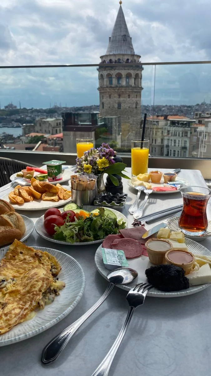 Breakfast table on a rooftop terrace with Galata Tower in the background